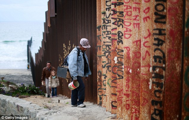 A Man Walks Along The Border Wall On The Mexican Side In Tijuana