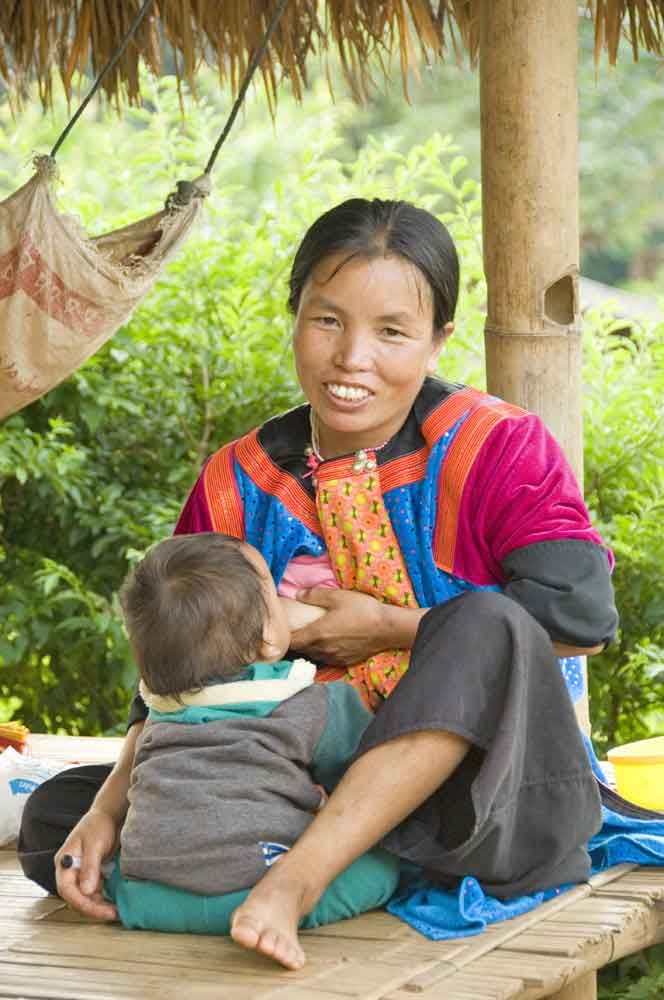 Lisu Mother Breast Feeding Her Baby In A Hill Tribes Village And Has Non