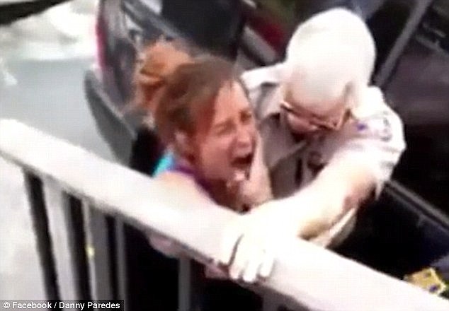 She Is Left In Agony The Punch As Another Policeman Restrains Her