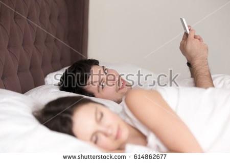 Stock Photo Cheating Husband Using Mobile Phone Lying In Bed Next To His Sleeping Wife Texting To Lover