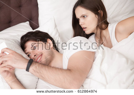 Stock Photo Shocked Woman Noticing Her Husband Checking His Smartphone And Texting His Lover While Lying Next