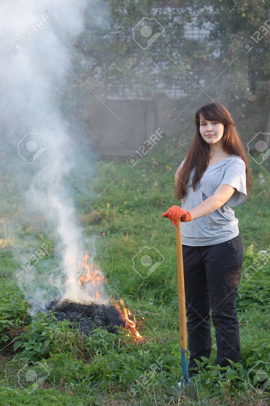 Teen Girl Burn Out Grass In The Garden Ukraine Stock Photo