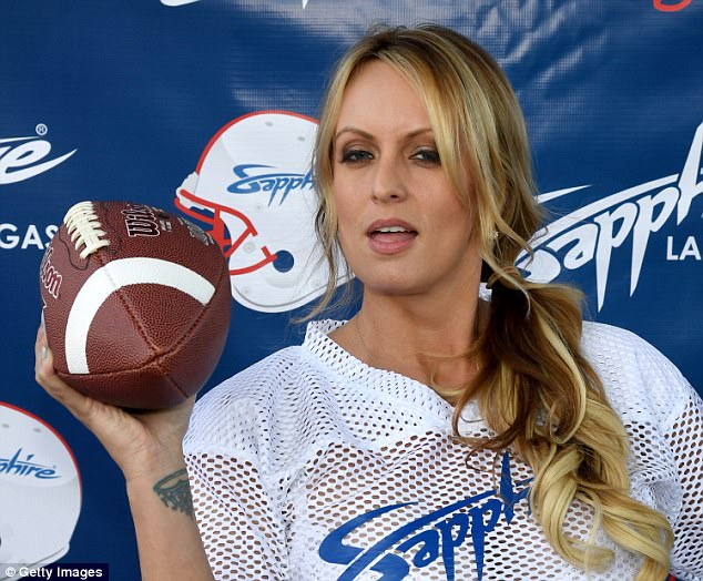 The Porn Star Wearing A Sapphire Football Jersey Holds A Ball In Her Right Hand